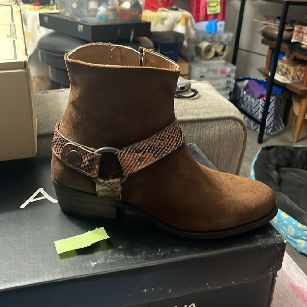 suede boots from ARTISAN BY ZIGI feature a sleek snakeskin pattern buckle.